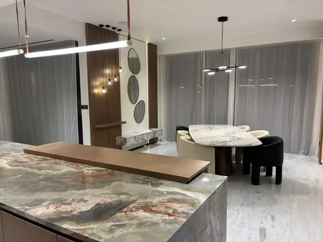 Jumeirah Golf Estates villa: Kitchen island in veined stone with a timber breakfast top
