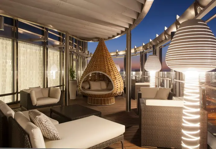 Palm Jumeirah penthouse: Covered terrace at dusk with a hanging rattan seat